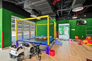 Ein Spielbereich mit Trampolin, Sicherheitsnetz und Spielzeugauto.