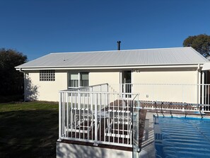 A two-story house with a covered deck and a swimming pool. - Tiberius House | Brand New Luxury Retreat with Heated Pool, Sauna & Pickleball (Saint Andrews Beach)