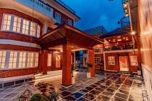 A hotel courtyard with a covered seating area, a pool, and a bar/lounge area. - Hotel Balcony House (Kathmandu)