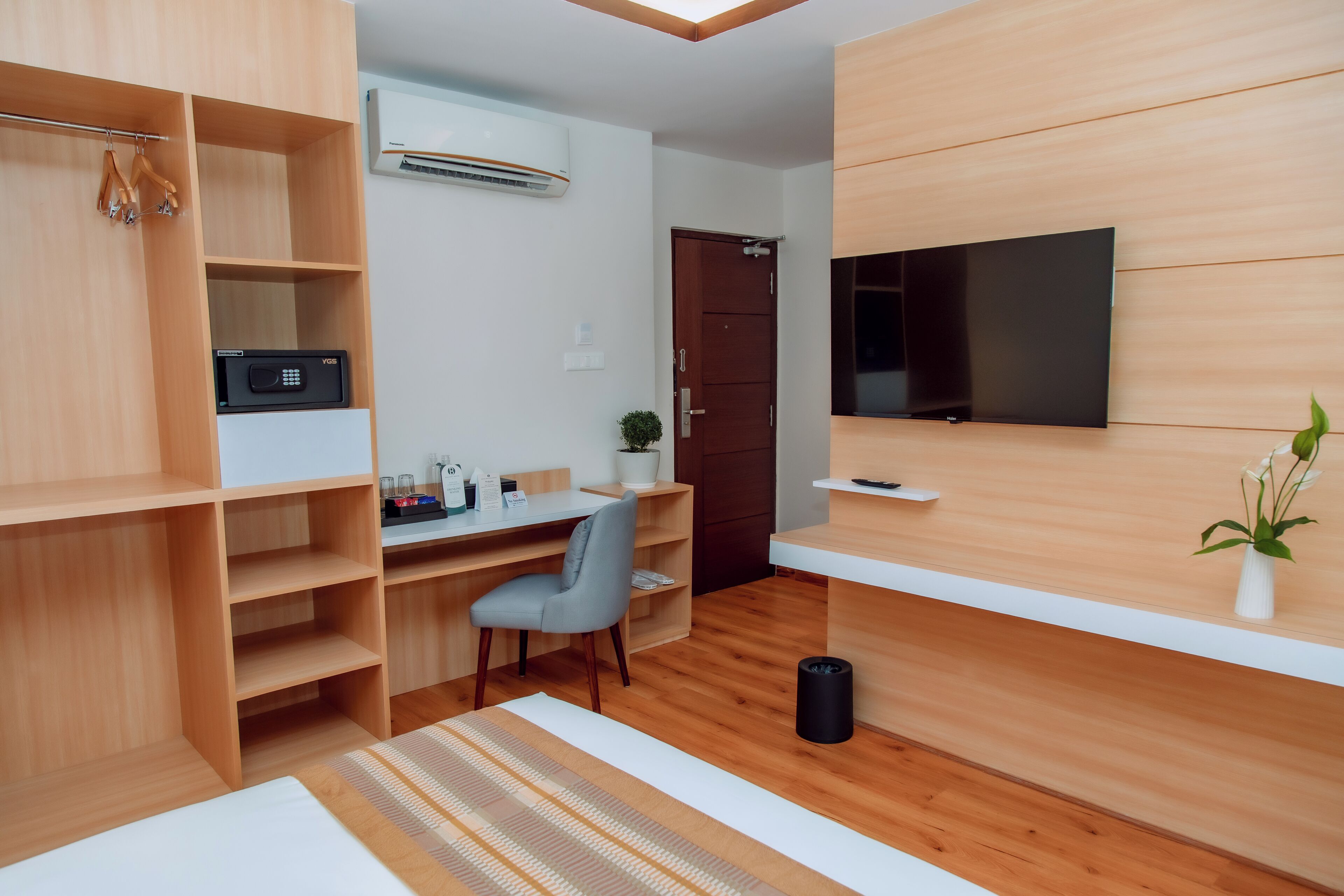Una habitación moderna y luminosa con escritorio de madera, silla y estanterías.