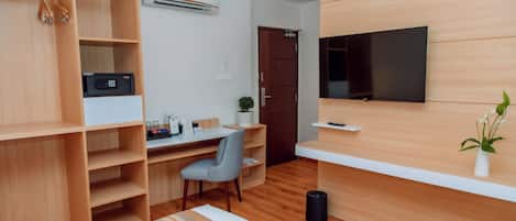 A modern, well-lit room with a wooden desk, chair, and shelving.