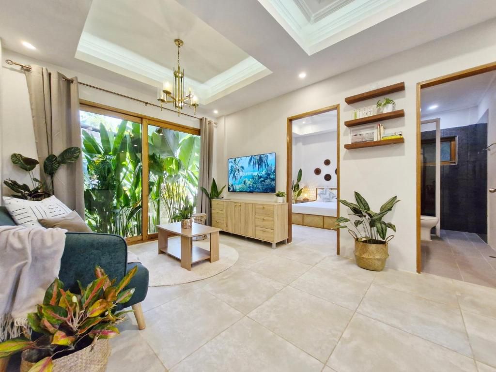 A modern living room with a television, a sofa, a coffee table, and a dining area.