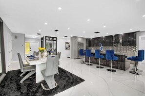A modern kitchen with dark cabinetry and a marble countertop.