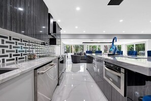 A modern kitchen with a central island, built-in appliances, and a seating area with a view.