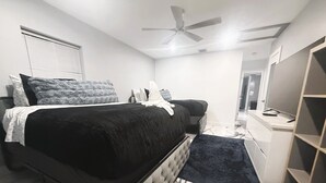 A bedroom with a bed, a desk, and a wardrobe.