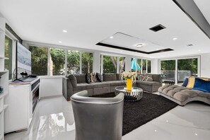 A modern living room with a sofa, coffee table, and a TV stand.