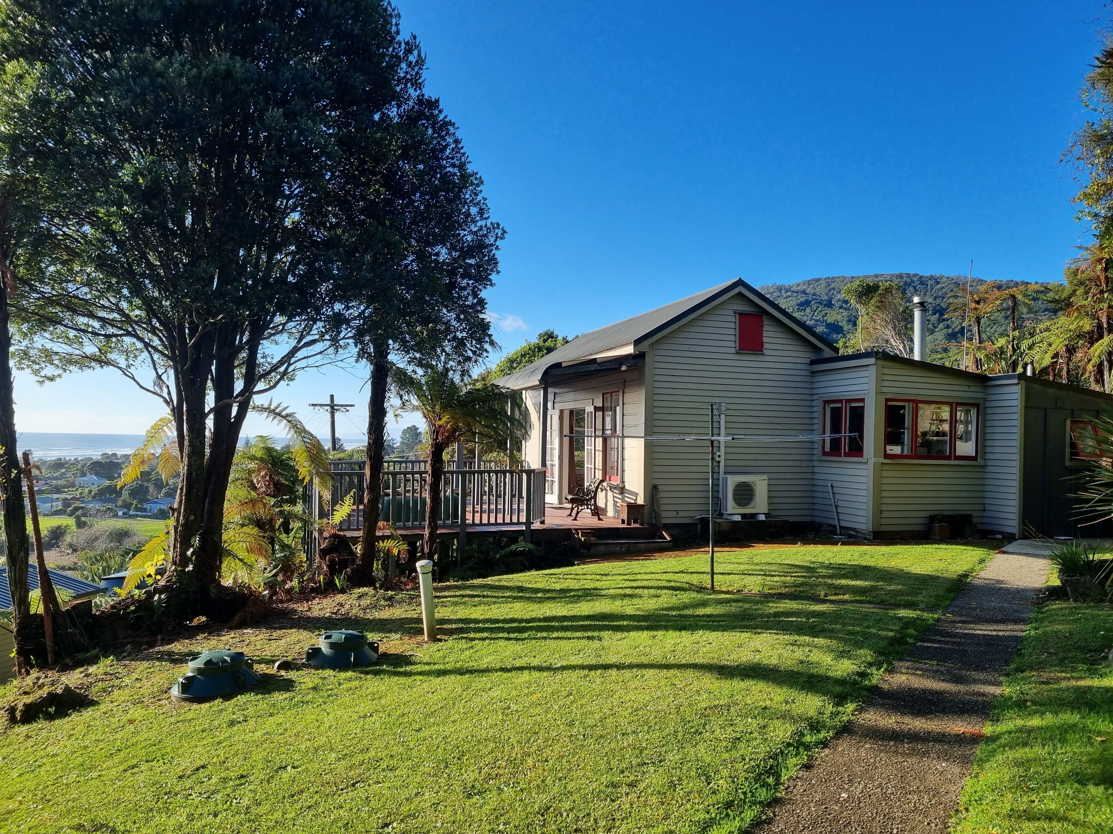A house with a porch, a lawn, and a view of the landscape.