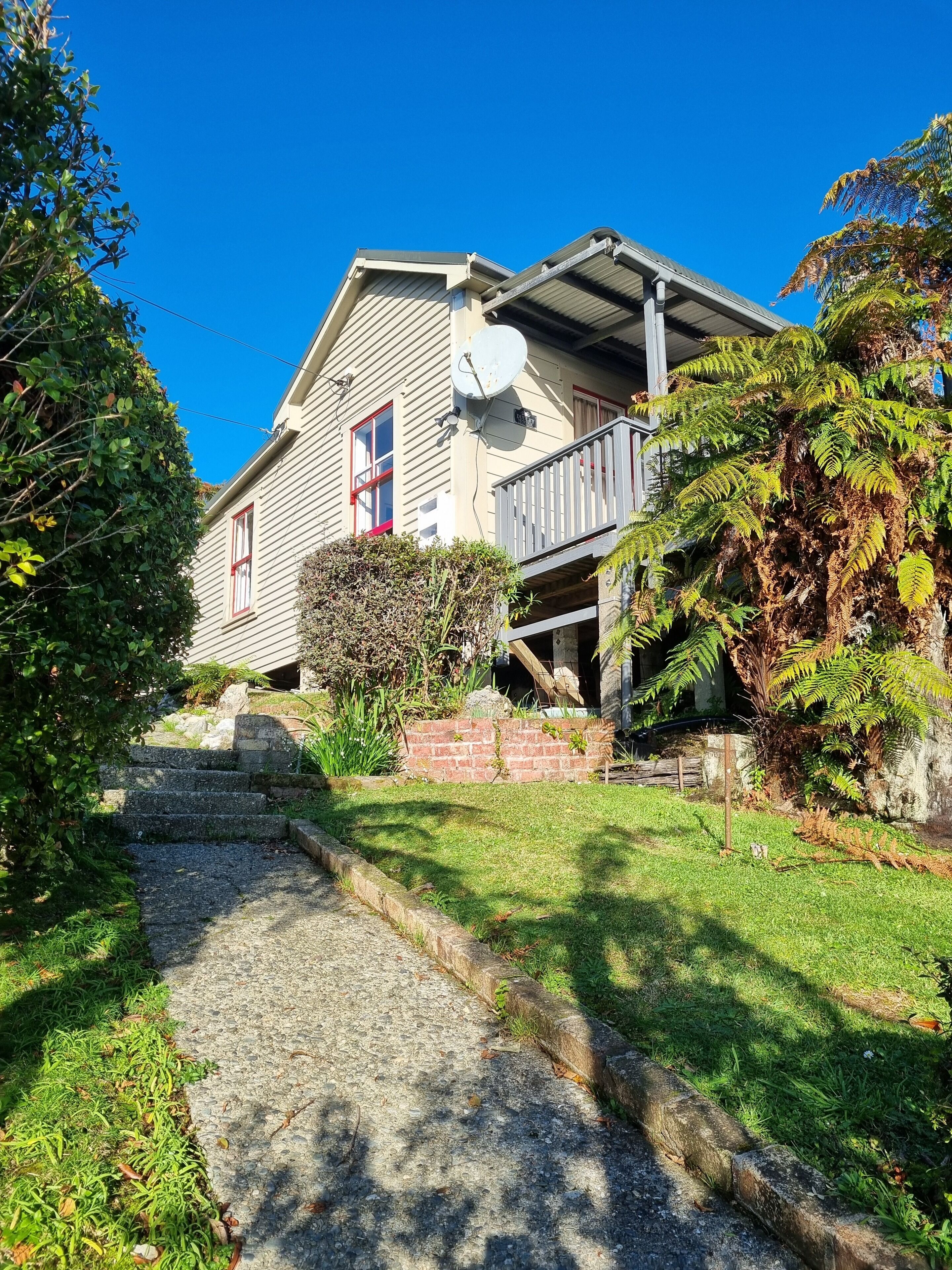 A house with a sloped roof, a satellite dish, and a small porch.
