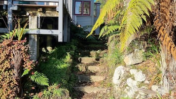 A residential area with a staircase leading to a house with a red window.