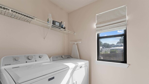A laundry room with two Maytag washers and dryers, a drying rack, and a window with a view of a parking lot. - Birdie's Nest and 2bdr Condo (Branson)