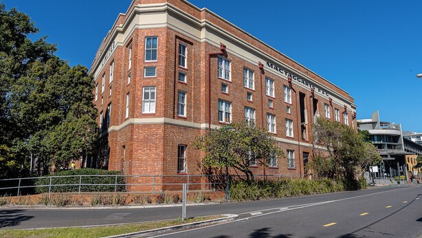 A red brick building with multiple windows and a flat roof. - Mactaggarts Place Apartments (Teneriffe)