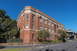 A red brick building with multiple windows and a flat roof. - Mactaggarts Place Apartments (Teneriffe)