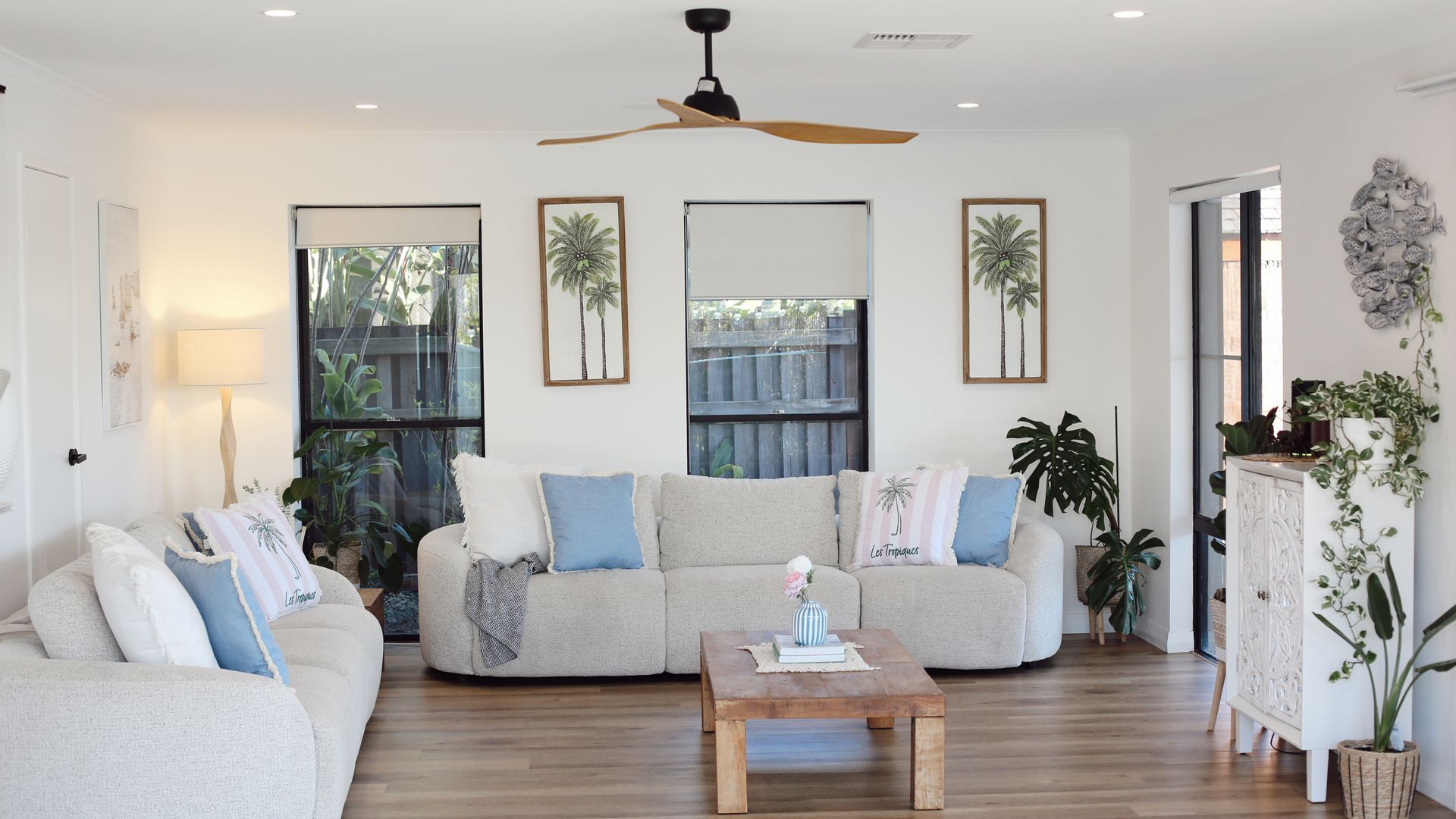 A living room with a sofa set, a coffee table, and a ceiling fan.