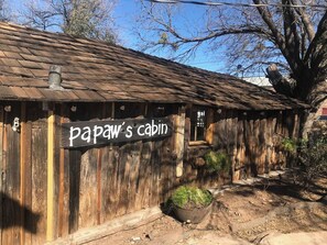 Een rustieke houten chalet met een bord waarop 'papaw's cabin' staat.