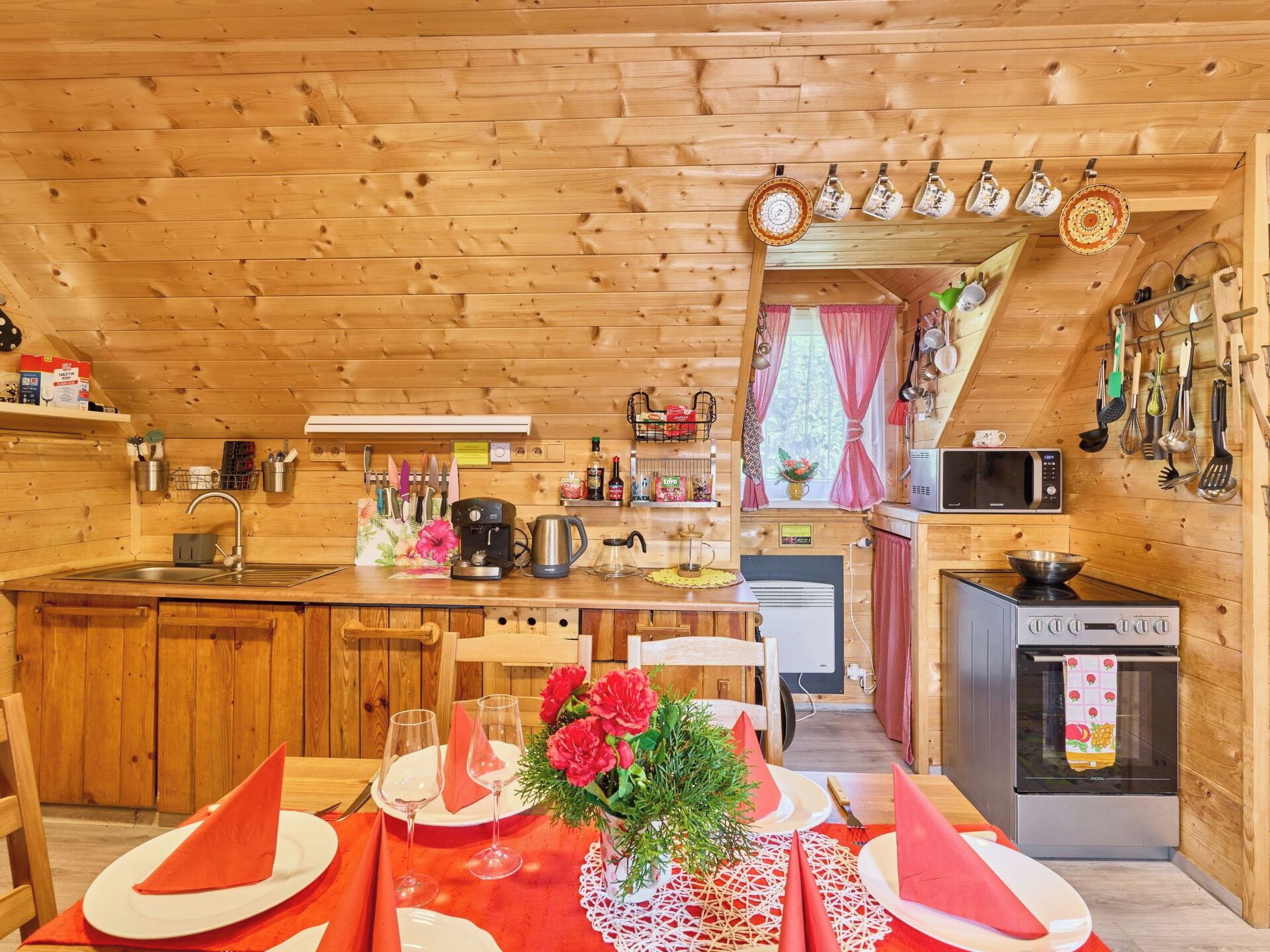 Una cabaña de madera acogedora con cocina, comedor y un pequeño salón.