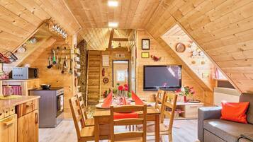 Un intérieur chaleureux en bois, comprenant un coin repas, une cuisine et un espace de vie.