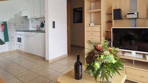 A modern apartment with a kitchen, living area, and entertainment unit. - Birke, (Grächen), by Interhome (Grächen)