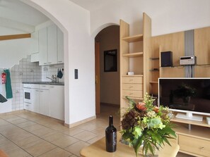 A modern apartment with a kitchen, living area, and entertainment unit. - Birke, (Grächen), by Interhome (Grächen)