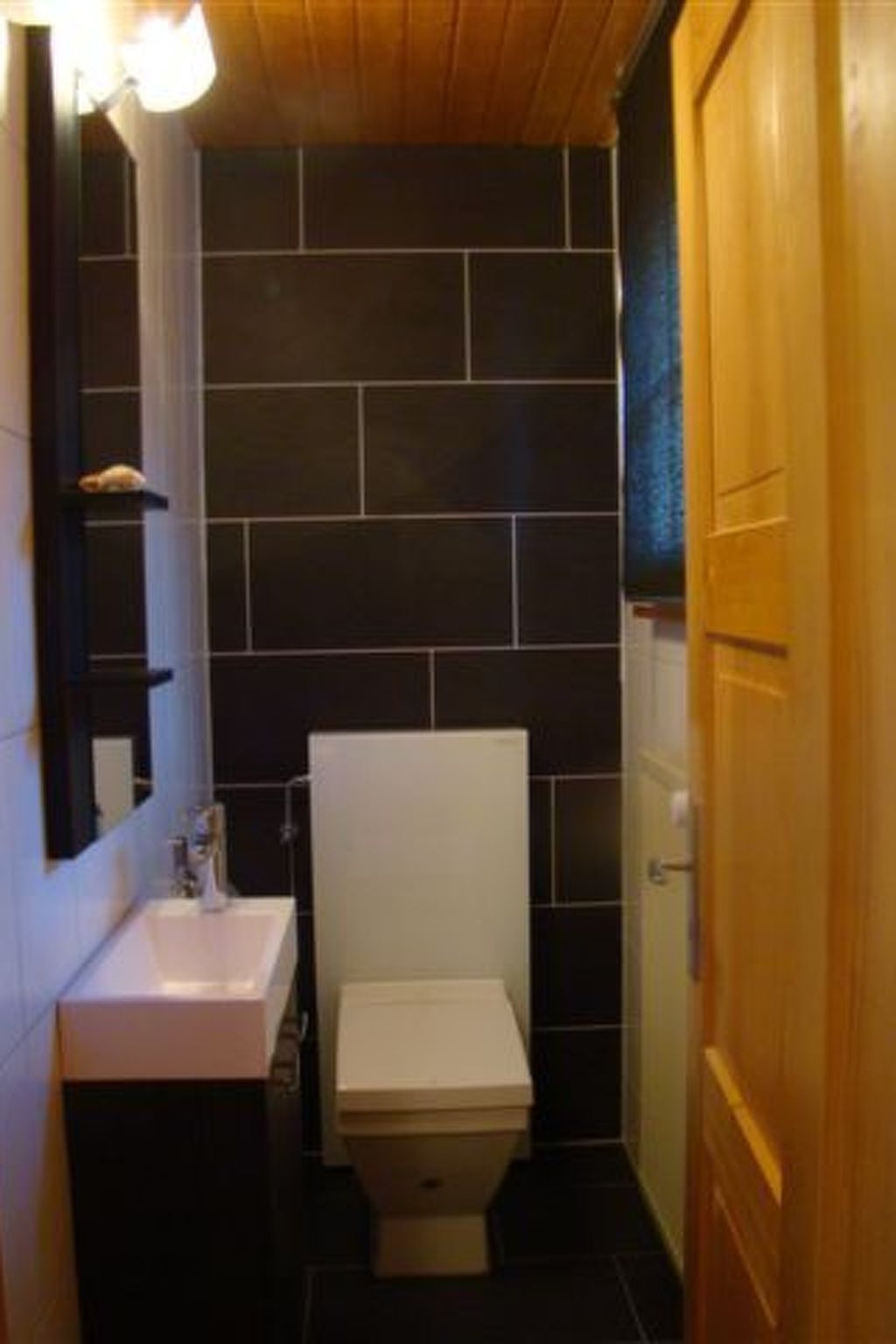Un bagno piccolo con il water, un lavandino e uno specchio.