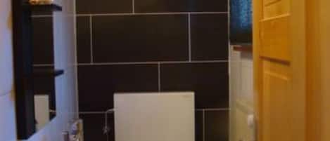 Un baño pequeño con inodoro, lavamanos y espejo.