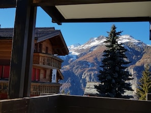 Un edificio de madera con un balcón que da a una montaña nevada.