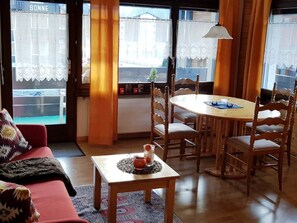 A cozy living room with a dining table, chairs, a sofa, and a small table with a decorative item. - David 26D, (Grächen), 1623 by Interhome (Grächen)