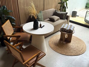 A modern living room with a round table, a sofa, and a small stool. - Private Jungle Pool Loft Near Canggu Beach • Guest Favorite • Fast WiFi (Canggu)