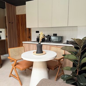 A modern kitchen with a round table, two chairs, a coffee machine, and a microwave. - Private Jungle Pool Loft Near Canggu Beach • Guest Favorite • Fast WiFi (Canggu)