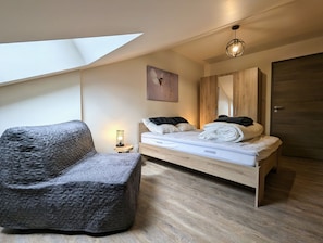 A modern bedroom with a loft-style bed, a cushioned chair, and a skylight. - Le Martin Pêcheur: Between Nature and Downtown. (Gérardmer)