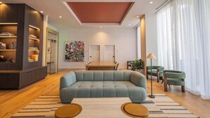 Ein modernes Wohnzimmer mit einem Ecksofa, einem Esstisch und einem Bücherregal.