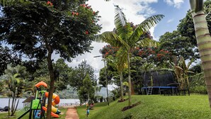 En park med legeplads, en lille scene og udsigt til et vandareal.