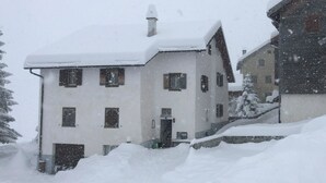 Ein mehrstöckiges Gebäude mit verschneitem Dach und Außenbereich.