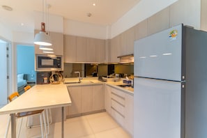 A modern kitchen with a central island, stainless steel appliances, and a built-in oven. - Cassia Residences Spacious 2BR with Lagoon View (Choeng Thale (Thalang District))