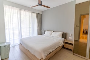 A modern bedroom with a large bed, a ceiling fan, and a view of a room with a bed. - Cassia Residences Spacious 2BR with Lagoon View (Choeng Thale (Thalang District))
