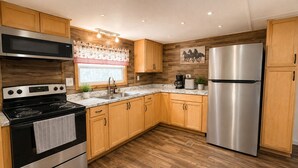 Una cocina moderna con gabinetes de madera, electrodomésticos de acero inoxidable y encimera de mármol.