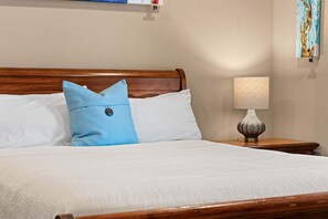 A neatly made bed with white bedding and a single blue pillow. - Yakov's Hideaway - Lakefront (Hollister)