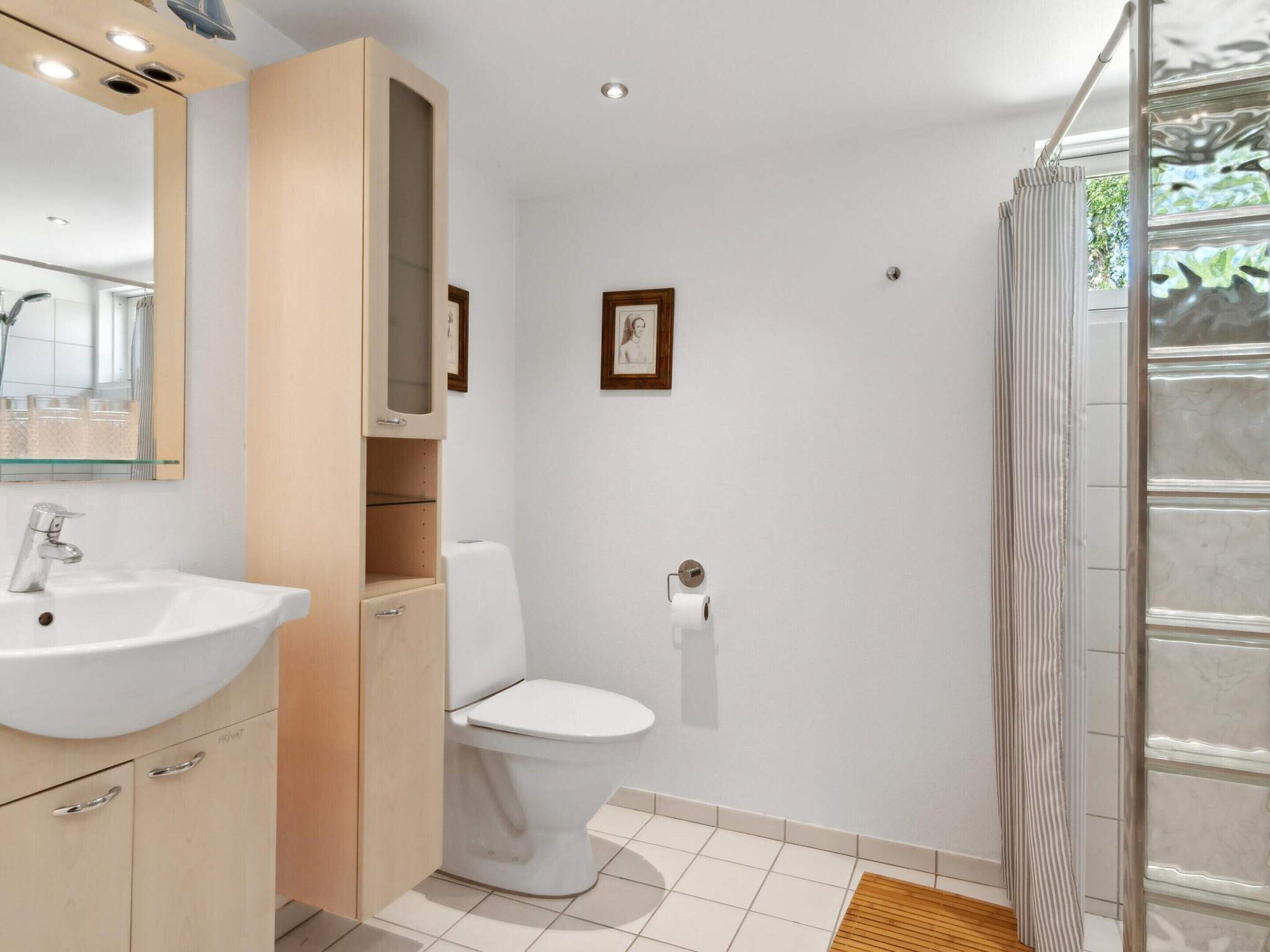 Un bagno moderno con lavabo, WC e doccia.