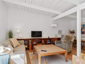 A modern living room with a sofa, coffee table, and a television. - 5 Star Holiday Home in Graested (Graested)