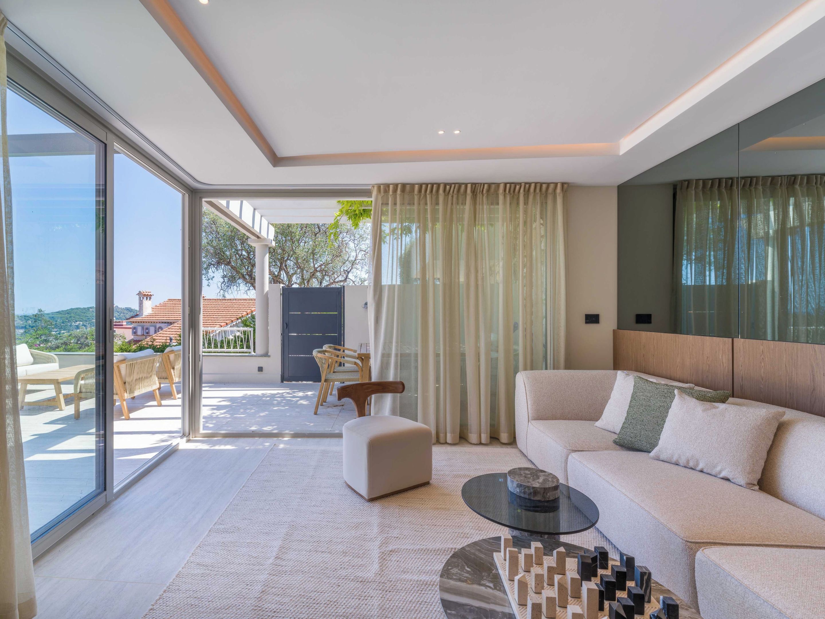Una sala moderna con un sofá, una mesa de centro y vistas al exterior.