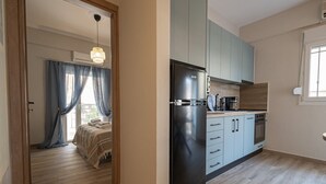 Una cocina moderna con refrigerador negro, alacenas azul claro y encimera de madera.