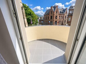 A balcony with a curved floor, overlooking a street with historic buildings and a clear sky. - Zum Rheinberg - Balcony Suite (Braubach)