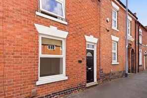 A red brick building with white-framed windows and a black door. - Stylish 3BR, Warwick Hosp, Contractor long stays (Warwick)