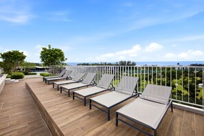 A rooftop terrace with sun loungers and a view of the landscape. - Skypark Laguna 1BR, Rooftop Pool, Walk to Bang Tao & Boat Avenue (Sakhu)