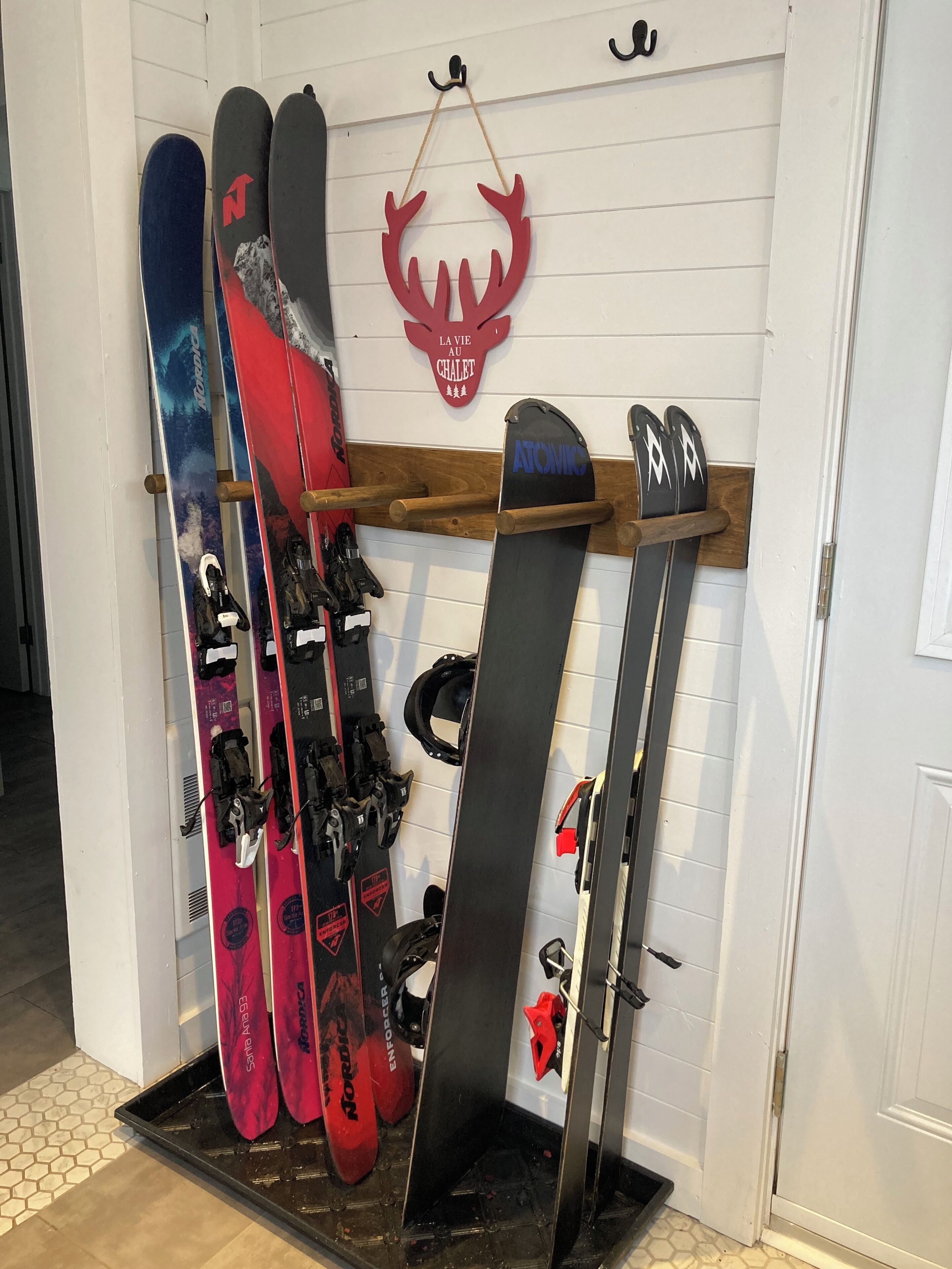 Un porte-skis contenant différents types de skis et de chaussures de ski.