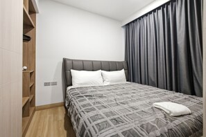 Une chambre à coucher avec un lit, une armoire et une fenêtre avec des rideaux.