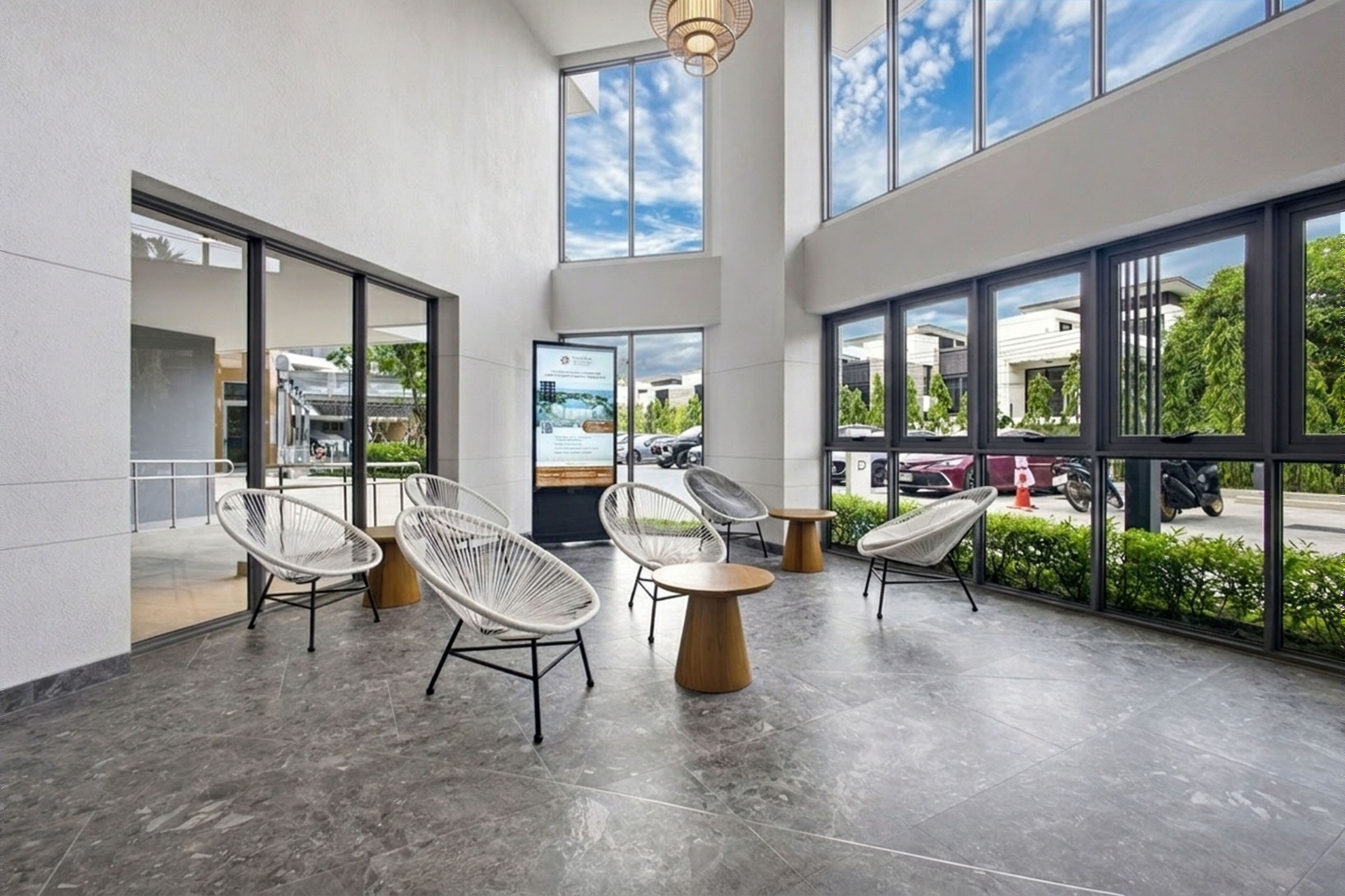 A spacious indoor area with large windows, modern chairs, and a clean, minimalist design.