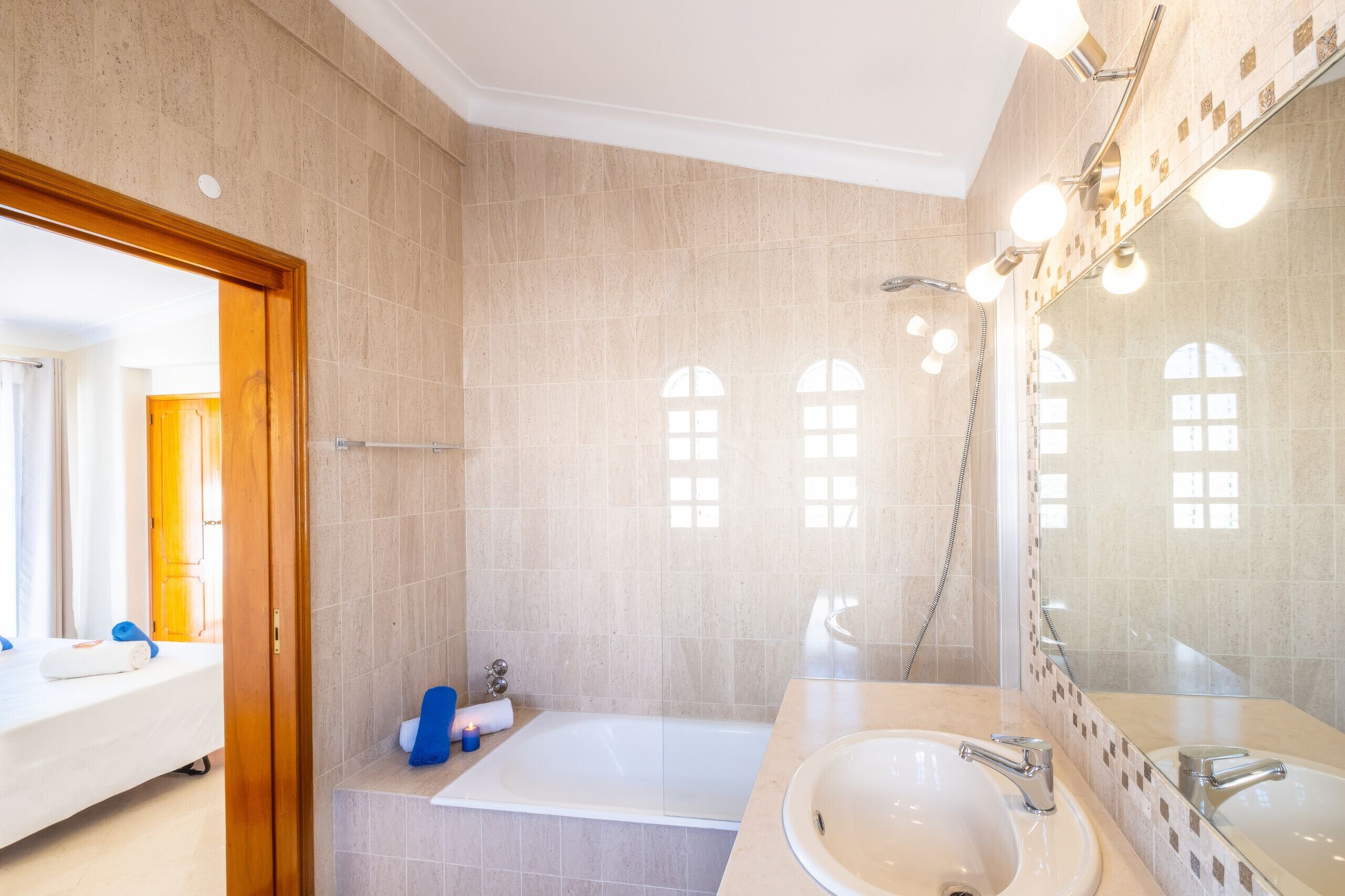 Une salle de bain moderne avec une baignoire, un grand miroir et un espace douche.