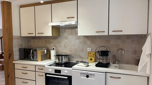 A modern kitchen with white cabinets, a microwave, a stove, and a dishwasher.