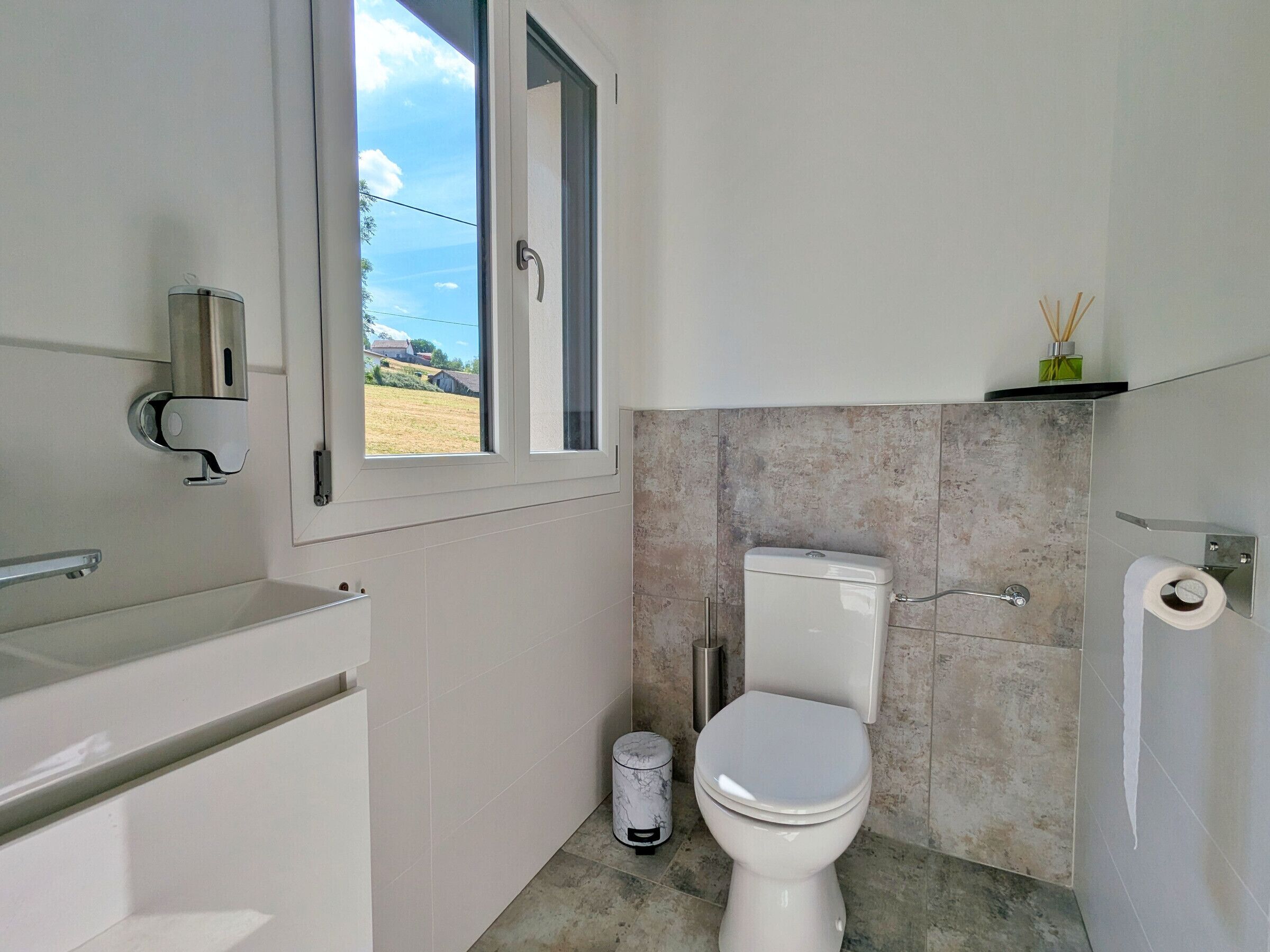 Un baño con inodoro, bidé y ventana.