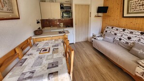 A compact living space with a kitchenette, a dining area, and a sofa. - Cozy apartment, balcony with slopes view - 4 guests (Montgenèvre)